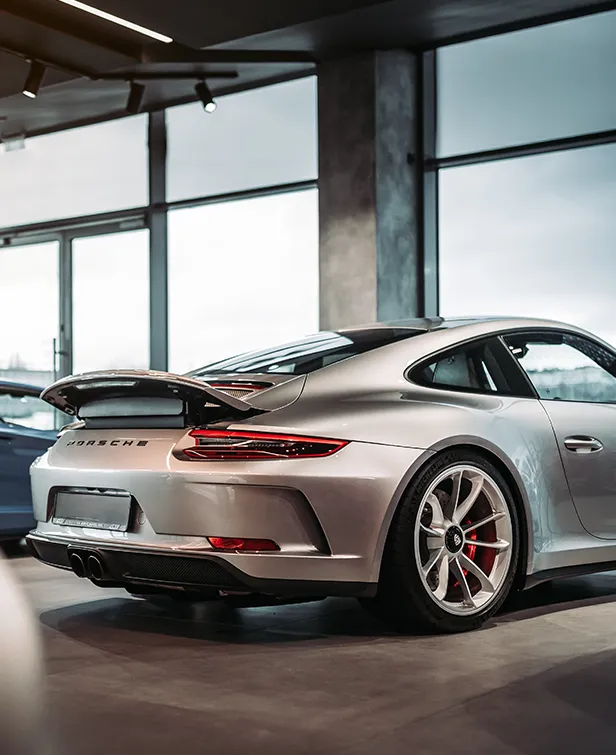 Photographie d'une Porsche vue de trois quarts de l'arrière dans une concession automobile